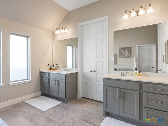 514 Orchard Way, New Braunfels, TX 78132 - bathroom featuring vaulted ceiling, two vanities, baseboards, and a closet