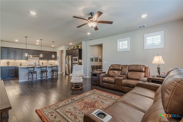 living area with dark wood-style floors, recessed lighting, visible vents, and a ceiling fan