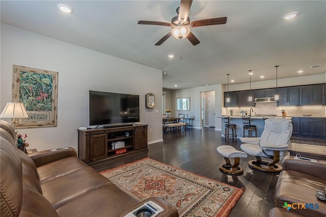 living room featuring ceiling fan, dark hardwood / wood-style flooring, and sink