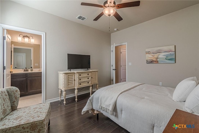 bedroom featuring wood finished floors, a ceiling fan, visible vents, baseboards, and ensuite bath