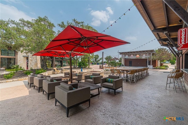 view of property's community featuring a bar, an outdoor living space, and a patio area