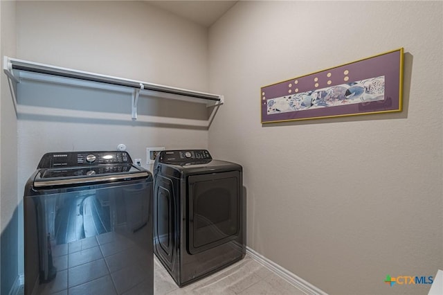 clothes washing area featuring separate washer and dryer and light tile patterned floors