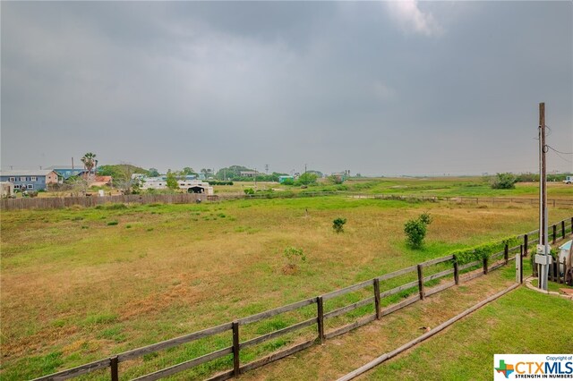 view of yard with a rural view and fence