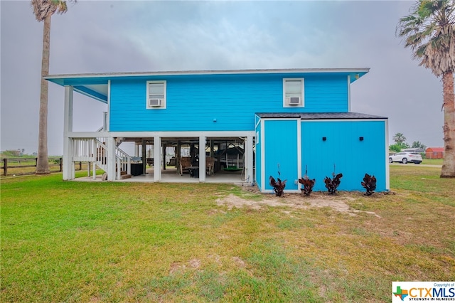 rear view of property with a yard, a patio, a carport, and stairs