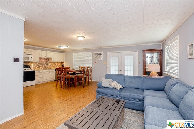 living room with french doors, light hardwood / wood-style flooring, and crown molding