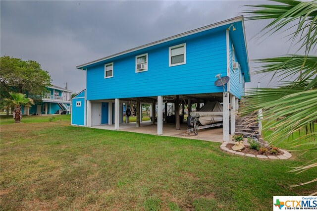 rear view of property featuring a carport, stairway, a patio area, and a yard