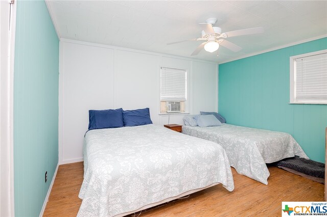 bedroom featuring hardwood / wood-style floors, ceiling fan, and crown molding