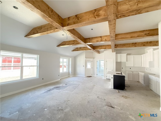 unfurnished living room featuring beam ceiling