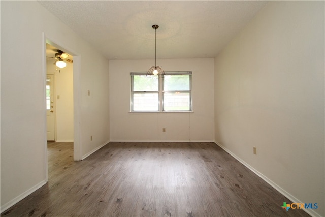 unfurnished room with a textured ceiling, ceiling fan, and dark wood-type flooring