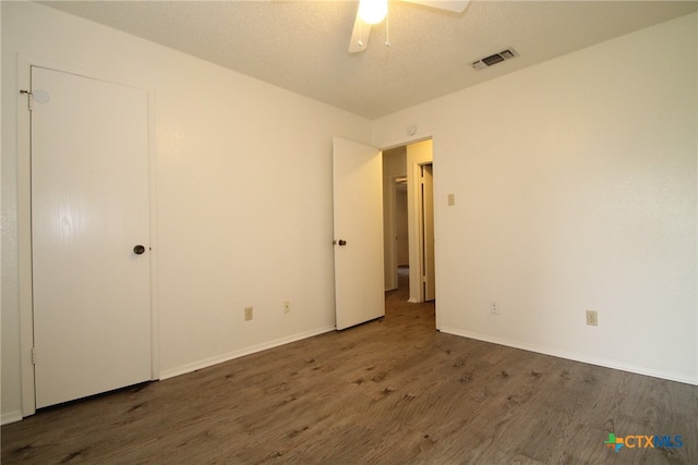 spare room featuring a textured ceiling, dark hardwood / wood-style floors, and ceiling fan