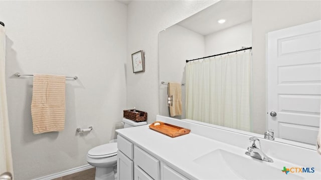 bathroom featuring a shower with curtain, vanity, and toilet