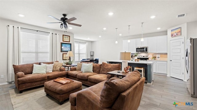 living room featuring ceiling fan and light hardwood / wood-style floors