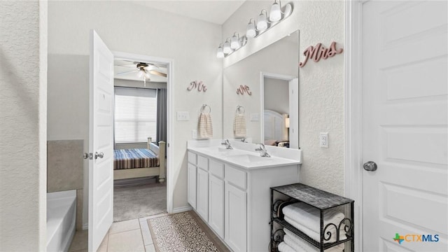 bathroom featuring vanity, a tub to relax in, tile patterned floors, and ceiling fan