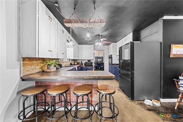 kitchen with white cabinets, a sink, ceiling fan, blue cabinets, and a peninsula