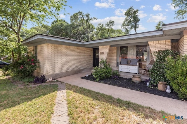 ranch-style house featuring a front lawn and brick siding