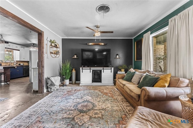 living room with visible vents, a ceiling fan, a fireplace, and finished concrete floors