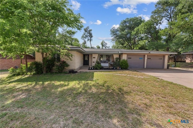 single story home featuring driveway, a front yard, an attached garage, and brick siding
