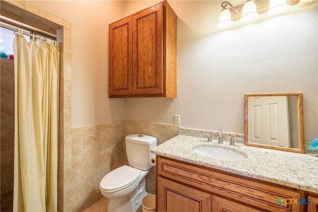 bathroom featuring tile walls, vanity, toilet, and a shower with curtain