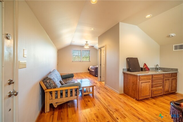 sitting room with ceiling fan, lofted ceiling, sink, and light hardwood / wood-style floors