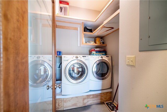 clothes washing area with electric panel and washer and dryer