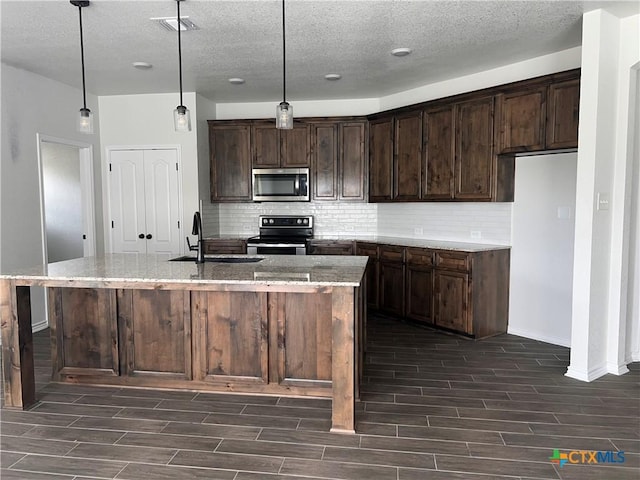 806 Dred Roger Cir, Killeen, TX 76542 - kitchen featuring stainless steel appliances, wood finish floors, decorative backsplash, and a textured ceiling