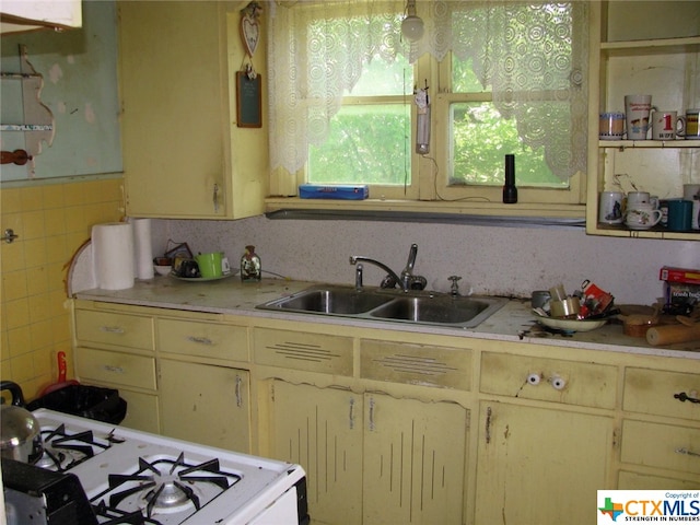 kitchen featuring white gas range and sink