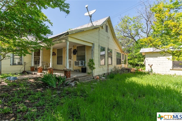 view of side of home featuring a porch and cooling unit