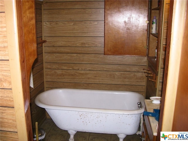 bathroom with wooden walls and a tub