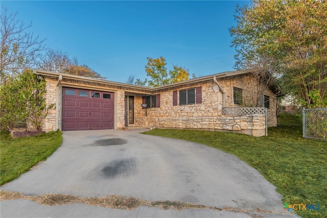 ranch-style house with a garage and a front lawn