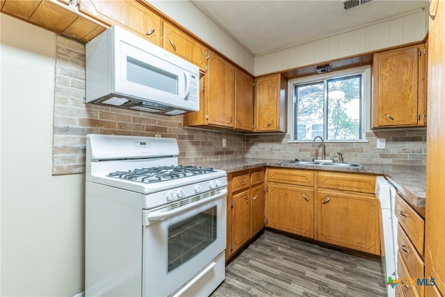 kitchen with white appliances, sink, decorative backsplash, and dark hardwood / wood-style flooring