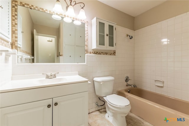 full bathroom with toilet, tile walls, tile patterned flooring, tiled shower / bath combo, and vanity