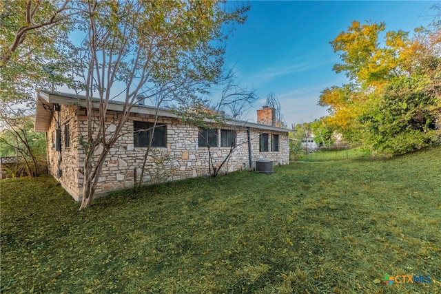 back of property featuring central AC unit and a yard