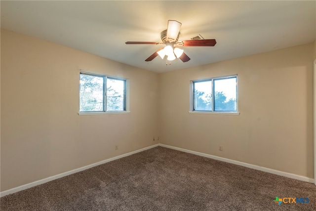 empty room featuring carpet, a healthy amount of sunlight, and ceiling fan