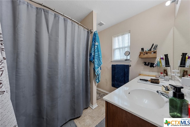 bathroom featuring tile patterned flooring, vanity, and a textured ceiling