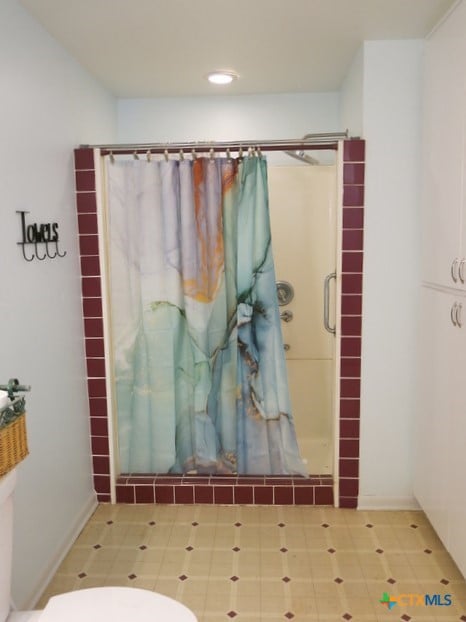 bathroom featuring toilet and a shower with curtain