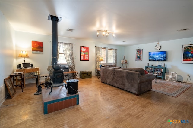 living room with light hardwood / wood-style flooring and a wood stove