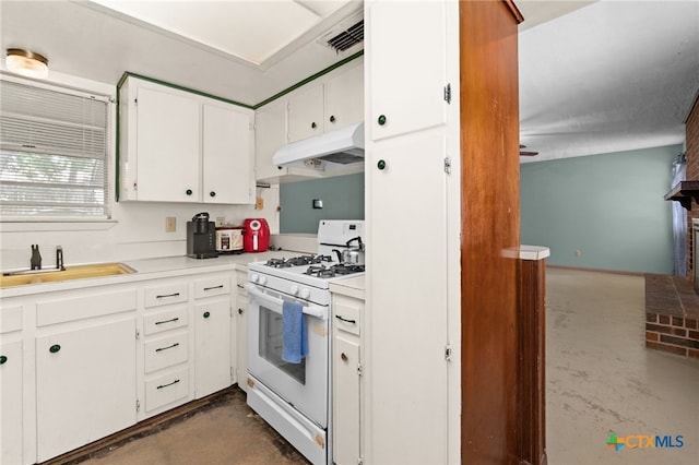 405 Carothers St, Copperas Cove, TX 76522 - kitchen featuring white gas stove, finished concrete flooring, under cabinet range hood, white cabinetry, and light countertops