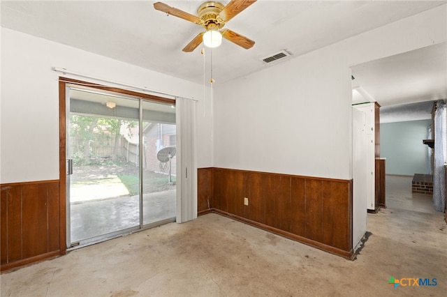 405 Carothers St, Copperas Cove, TX 76522 - spare room featuring wooden walls, unfinished concrete floors, wainscoting, and ceiling fan