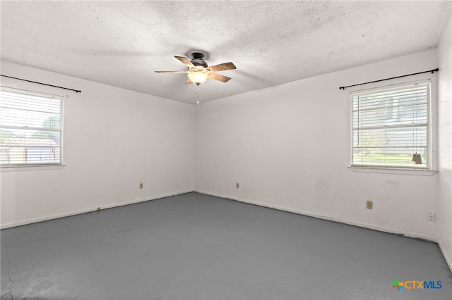 405 Carothers St, Copperas Cove, TX 76522 - empty room featuring a ceiling fan, healthy amount of natural light, finished concrete flooring, and a textured ceiling