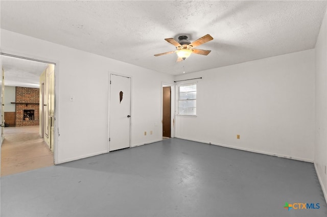 405 Carothers St, Copperas Cove, TX 76522 - unfurnished bedroom with a textured ceiling, finished concrete flooring, a fireplace, and a ceiling fan