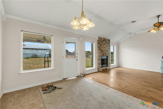 unfurnished living room featuring ceiling fan with notable chandelier, a fireplace, light hardwood / wood-style flooring, crown molding, and lofted ceiling