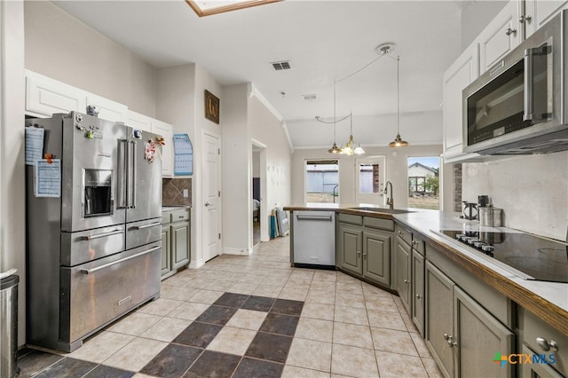 kitchen featuring stainless steel appliances, white cabinets, sink, gray cabinets, and pendant lighting