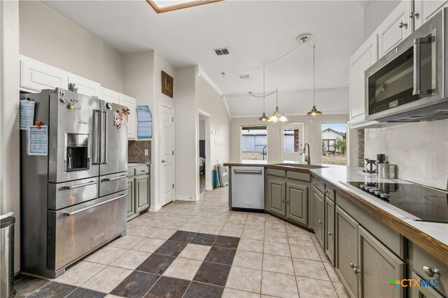 kitchen featuring sink, gray cabinetry, hanging light fixtures, appliances with stainless steel finishes, and white cabinets