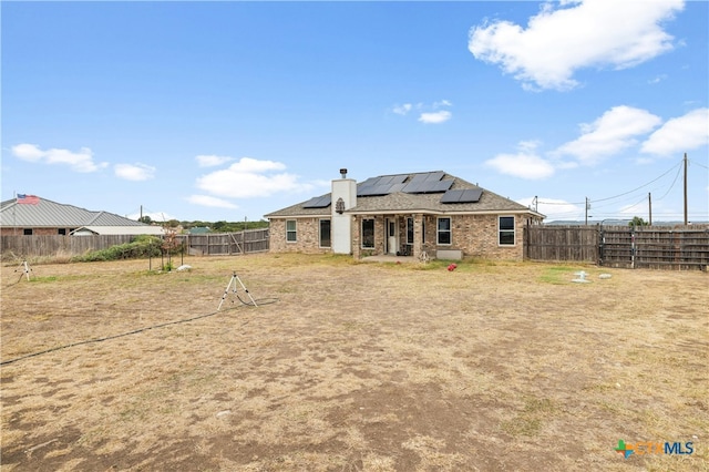 rear view of property with solar panels