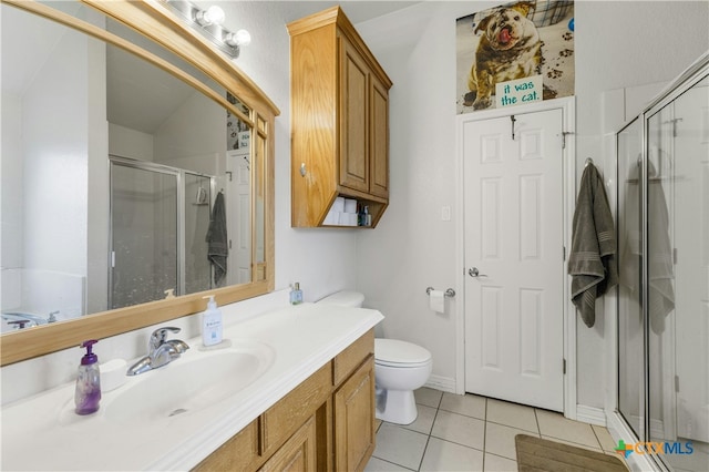 bathroom with toilet, vanity, an enclosed shower, and tile patterned floors