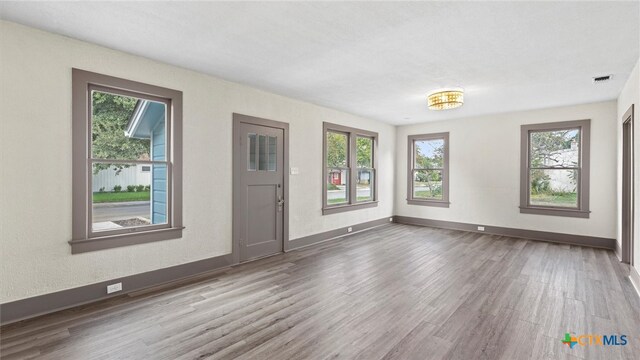 interior space with a wealth of natural light and hardwood / wood-style floors