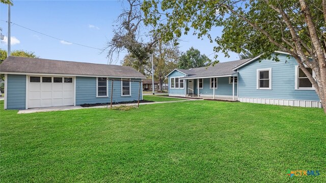 view of front of property featuring covered porch, a front yard, and a garage