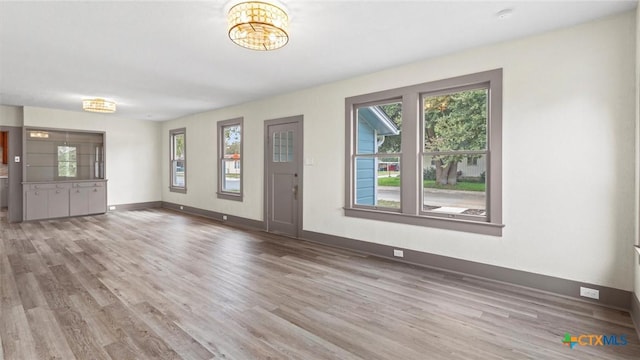 603 E Cedar St, Seguin, TX 78155 - unfurnished living room with wood finished floors and a chandelier