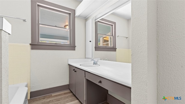 bathroom featuring hardwood / wood-style floors, vanity, and a tub