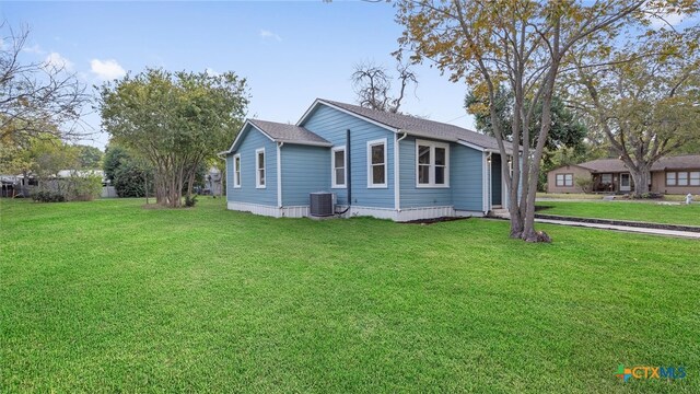 view of front of property with cooling unit and a front yard